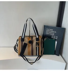 Close-up of striped canvas tote bag with woven handles and decorative side zipper detail