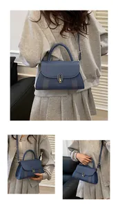 Detail of blue leather crossbody bag showing side grey mesh texture and gold metal lock
