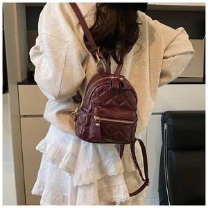Macro shot of burgundy quilted leather backpack with elegant gold zipper details
