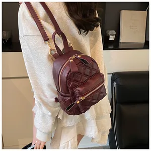 Detailed view of deep wine red quilted mini backpack with elegant gold zipper hardware