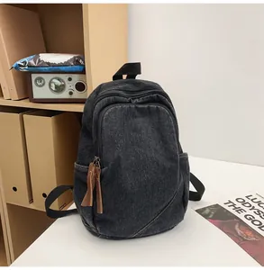 Detail of vintage washed denim backpack with brown faux leather zipper pull tabs