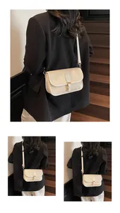 Détail d'un sac bandoulière crème avec texture lychee et boucle en métal dorée
