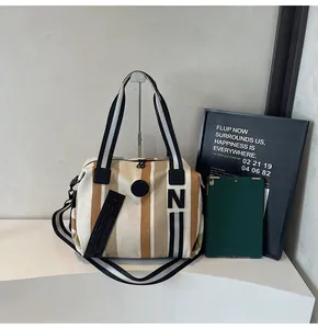 Detail of khaki striped large tote bag with zipper closure and woven handles for gym use