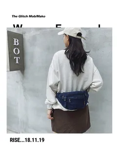 Detailansicht der blauen Denim-Gürteltasche mit Reißverschlussfächern im Streetstyle