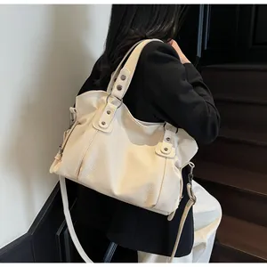 Detail of cream leopard-print tote bag showing textured leather and silver rivet hardware