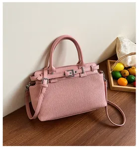 Dettaglio borsa rosa vintage con trama a pieghe verticali e fibbia in metallo argento