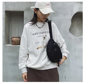Detail einer trendigen Jeans-Umhängetasche kombiniert mit weißem Katzen-Sweatshirt