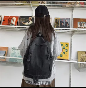Détail d'un sac à dos vintage en denim avec poches latérales sur une étudiante