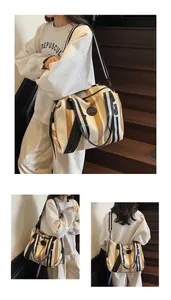 Detailed view of striped woven canvas bag showing detachable shoulder strap and logo