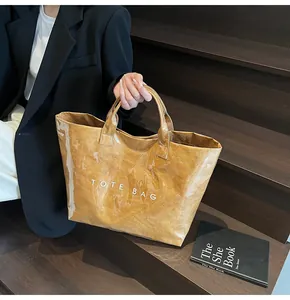 Detail of crinkled brown tote bag with TOTE BAG lettering on a wooden staircase