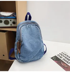 Close-up of vintage blue denim backpack with purple straps and leather zippers