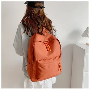 Detailed back view of a minimalist brick red backpack with durable canvas and side pockets