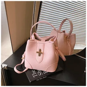 Detail of pink lychee leather bucket bag with gold clasp and mirrored back view