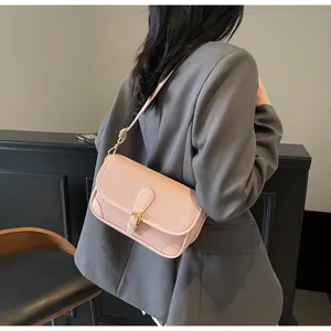Détail d'un sac à bandoulière en cuir litchi rose avec sangle réglable et boucle dorée