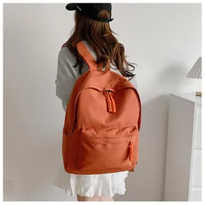 Side view of orange-brown canvas backpack with woven zipper pulls and side pockets