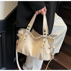 Detail of off-white tote bag showing litchi texture leather and metal rivets