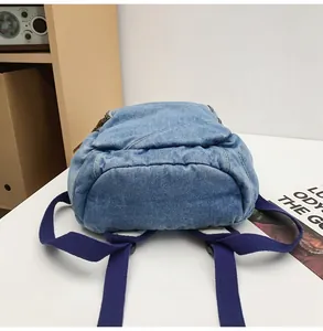 Detail view of the washed denim backpack bottom with smooth zippers and sturdy straps