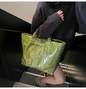 Green Tyvek tote bag with waterproof texture and white printed TOTE BAG text details