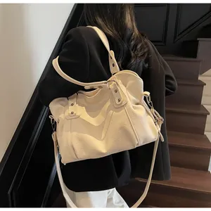 Chic beige faux leather bag with vintage rivets shown in a stylish lifestyle setting