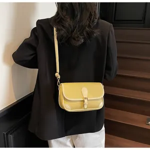 Détail du sac bandoulière jaune en cuir texturé avec crochet métallique et bandoulière