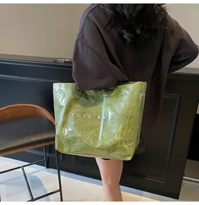 Detail of green tote bag with crinkled paper texture under transparent outer layer