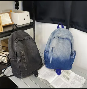 Détails de sacs à dos vintage en denim dégradé bleu et gris sur surface métallique