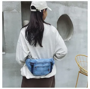 Detail der blauen Denim-Gürteltasche mit verstellbarem Gurt und Metall-Reißverschluss