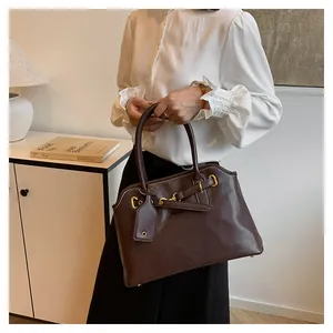 Vue détaillée du sac cabas en cuir marron foncé avec boucle en métal et breloque en cuir