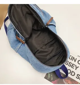 Internal view of denim backpack showing main compartment, zipper pocket and lining