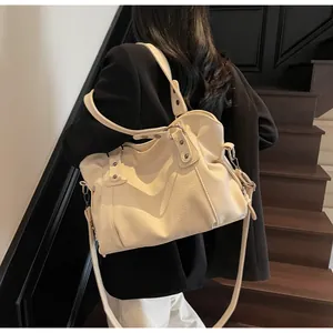 Detail of off-white lychee grain leather tote bag with dual straps and magnetic snap closure