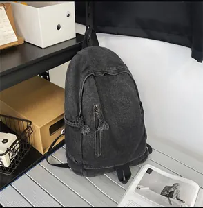 Gros plan du sac à dos en jean lavé avec détail de fermeture éclair et texture vintage