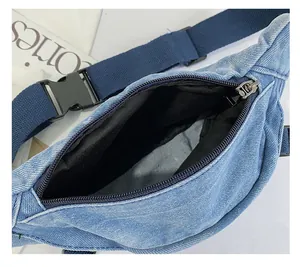 Detail der blauen Denim-Gürteltasche mit gewaschener Textur, Metallreißverschluss und Futter