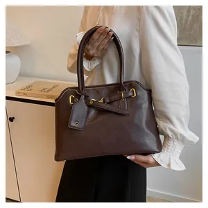 Vue détaillée du sac cabas chocolat avec boucles dorées élégantes et lanière décorative en PU