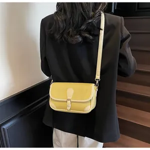 Sac bandoulière moutarde avec boucle en métal et bordure contrastée sur modèle
