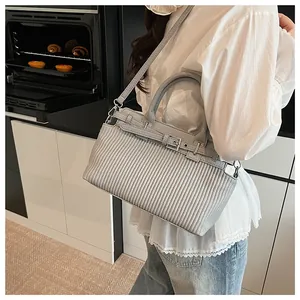 Borsa a tracolla grigio chiaro con trama a pieghe indossata in una cucina moderna