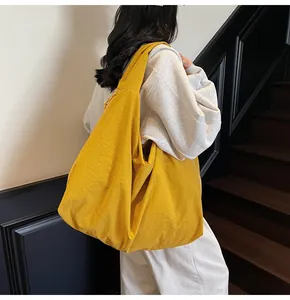 Detail of a lightweight bright yellow tote bag showing textured pleats on a shoulder bag