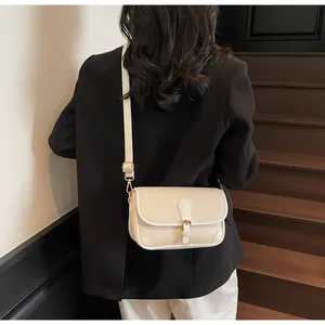 Vue détaillée du similicuir crème texturé et du fermoir doré sur le petit sac carré