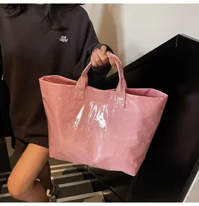Close-up of pink DuPont paper tote bag with white TOTE BAG text carried by model
