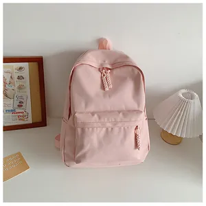 Close-up of light pink backpack with woven rope zipper details on a minimalist desk
