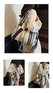 Detail of striped canvas tote bag showing the vertical pattern and adjustable shoulder strap