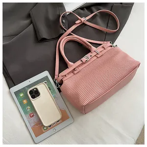 Dettaglio della borsa a mano rosa plissettata con texture, fibbie e grande capacità