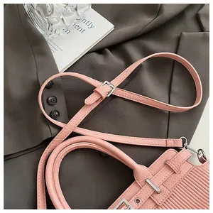 Dettaglio borsa in pelle rosa con trama a grana di litchi e pieghe laterali eleganti