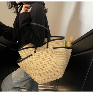 Detail of woven straw tote bag with black leather trim and side pocket on stairs