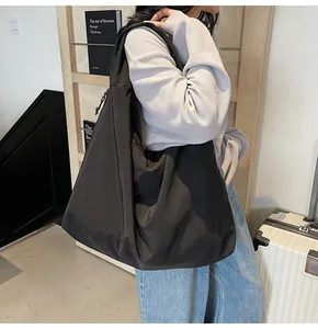 Close-up of a large black tote bag with side drawstring details and a comfortable wide strap