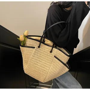 Macro view of woven straw tote bag featuring black leather trim and practical side pocket