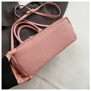 Dettaglio della borsa rosa in pelle martellata con cuciture e ferramenta argentata