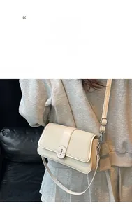 Detail view of woven crossbody bag with cream leather trim and oval metal lock
