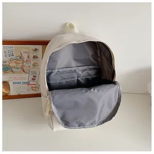 Interior view of cream backpack showing multiple compartments and laptop storage space