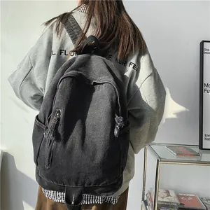 Sac à dos en denim noir délavé pour étudiantes avec dégradé et détails à franges