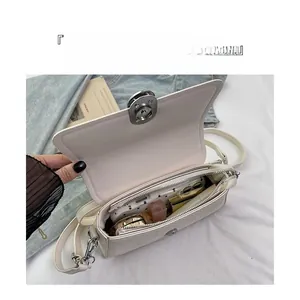 Top view of cream crossbody bag interior showing storage capacity and silver lock detail